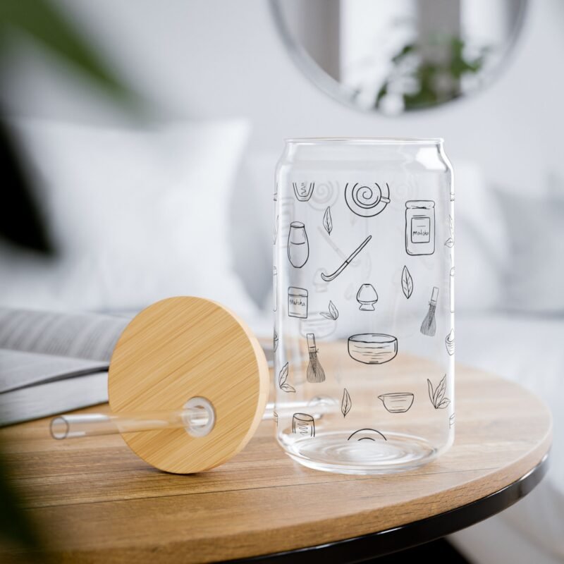 Clear glass tumbler with bamboo lid and straw, decorated with matcha-themed illustrations including matcha drinks, spoon, whisks, mug, and matcha leaves.