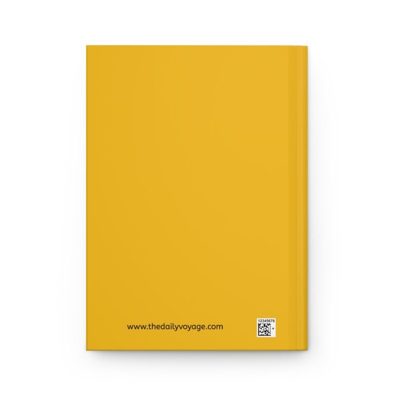 Yellow hardcover journal with the phrase ‘KALE Yeah!! I’m Vegan!!’ printed above illustrations of leafy greens and a green smoothie, placed on a white cloth with dried flowers.