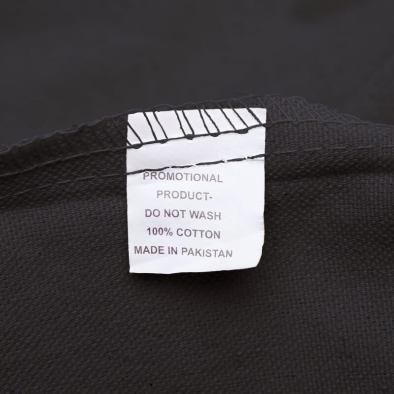 information tag inside of a black cotton canvas tote bag, 100% cotton made in pakistan