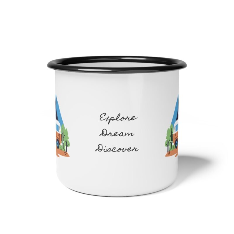 Colorful enamel mug with a camper van and mountain scene design placed on a wooden table at a forest campsite during sunrise.