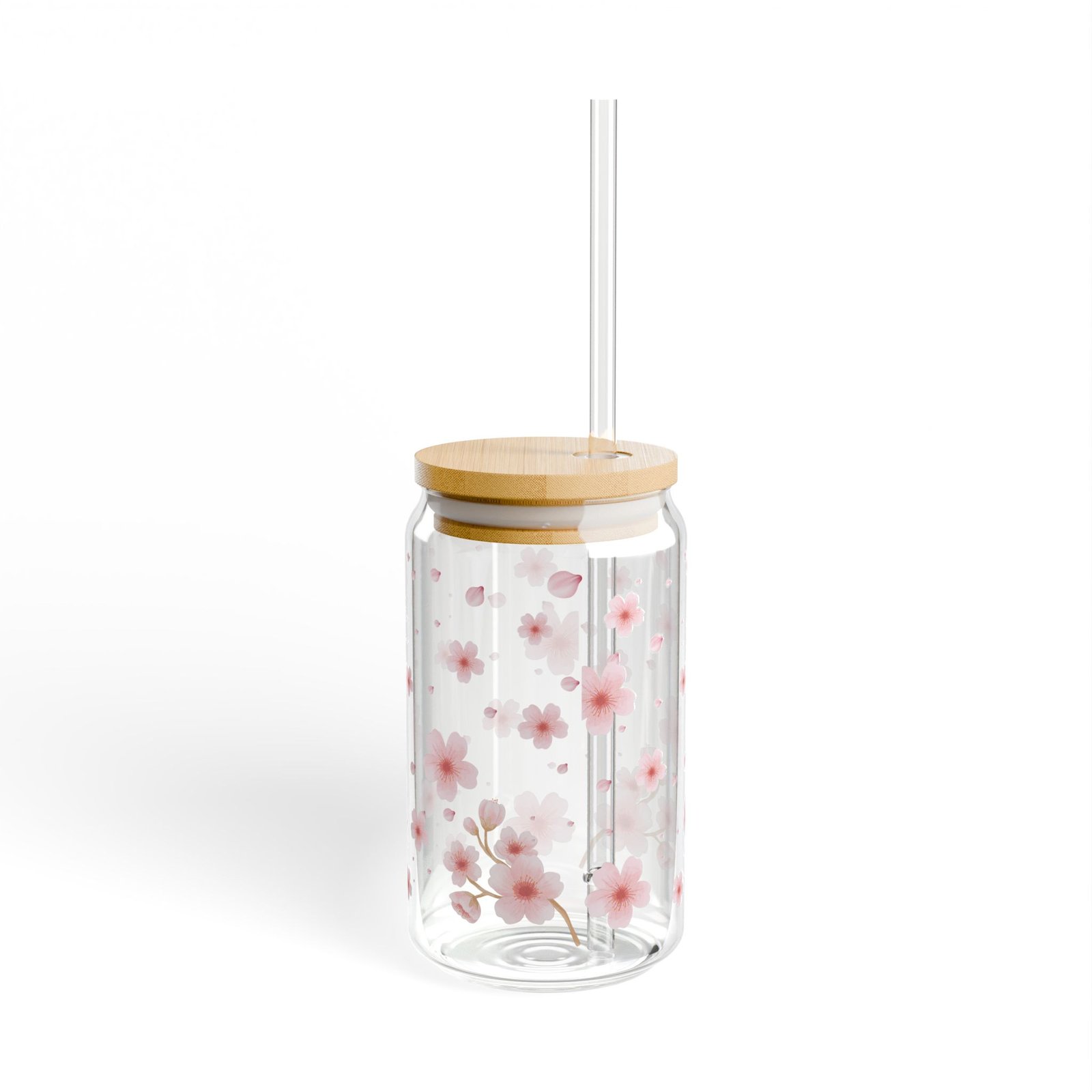 Clear glass can tumbler with pink cherry blossom design, bamboo lid, and glass straw on wooden table