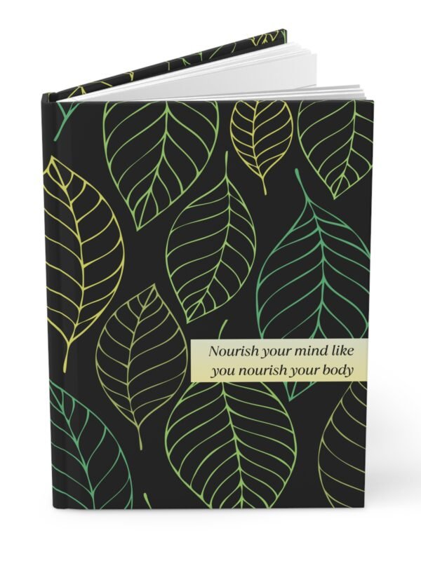 Black hardcover notebook with green and yellow leaf pattern and quote about nourishing the mind and body