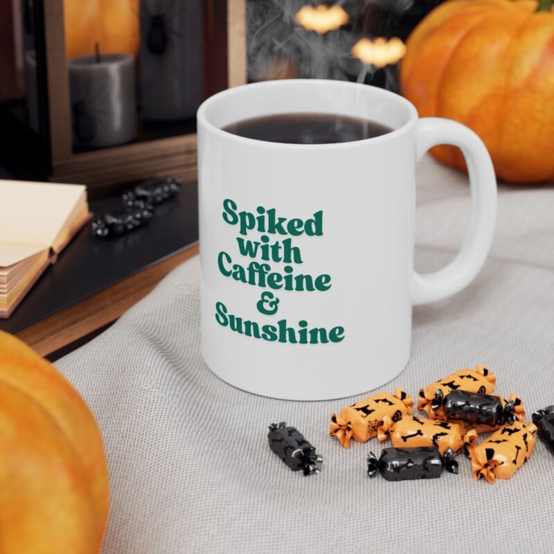 A ceramic mug features a sunny bright festive cactus illustration and writing of spiked with caffeine and sunshine