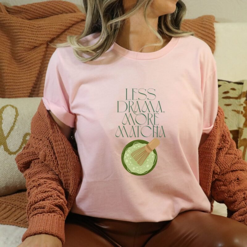 Soft Pink T-shirt with the phrase ‘Less drama more matcha!!’ printed above a bowl of matcha green tea and tea whisker illustrations, unisex cotton t shirt