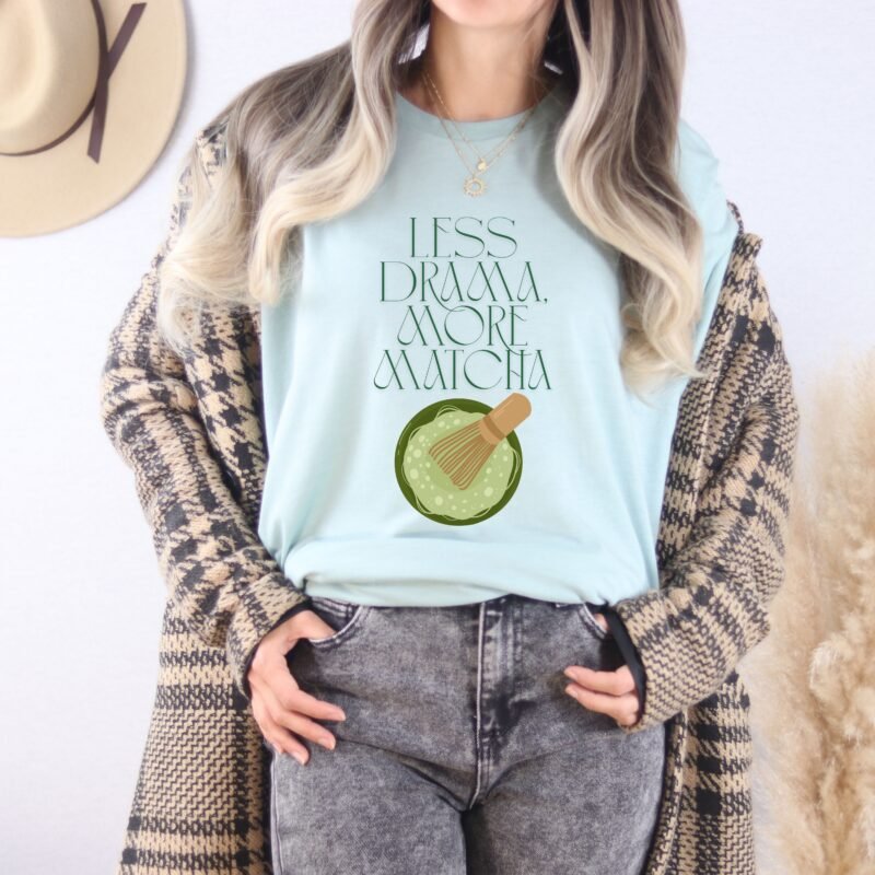 Dusty Blue T-shirt with the phrase ‘Less drama more matcha!!’ printed above a bowl of matcha green tea and tea whisker illustrations, unisex cotton t shirt