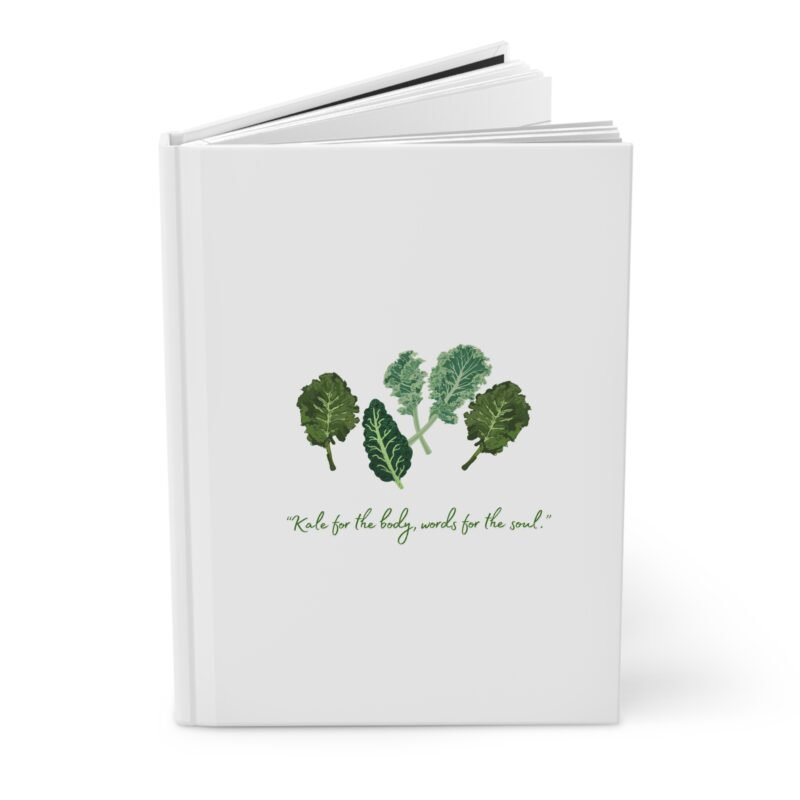 White Matte hardcover journal with the phrase ‘KALE for the body, words for the soul" printed below illustrations of leafy greens kale, placed on a white cloth with dried flowers.