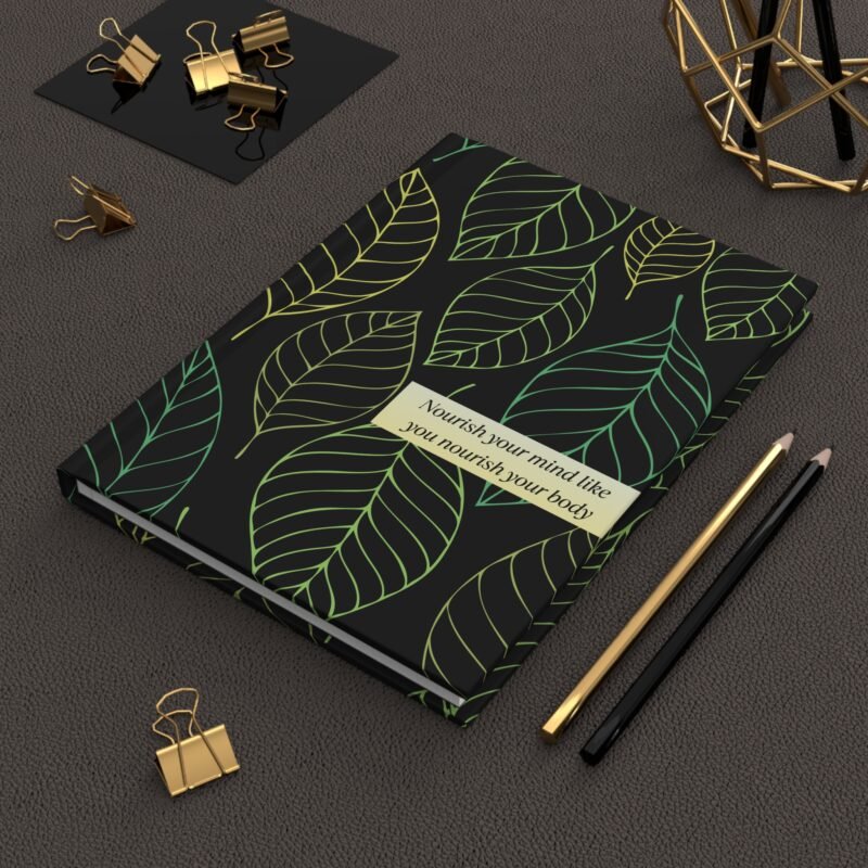 Black hardcover notebook with green and yellow leaf pattern and quote about nourishing the mind and body